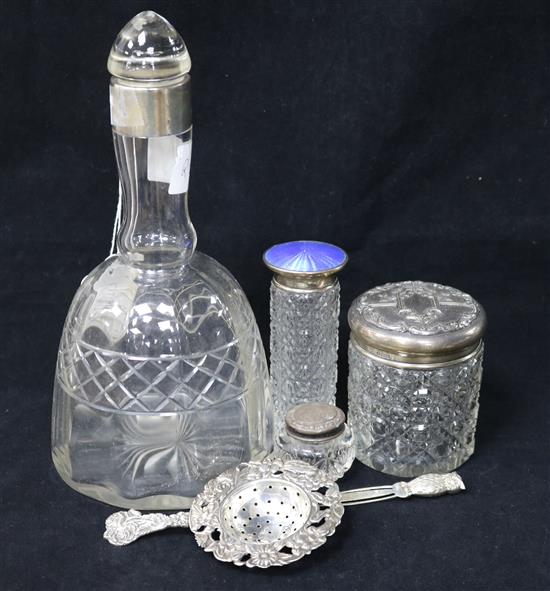 A George V silver topped decanter by Asprey & Co, an enamel topped bottle and three other items.